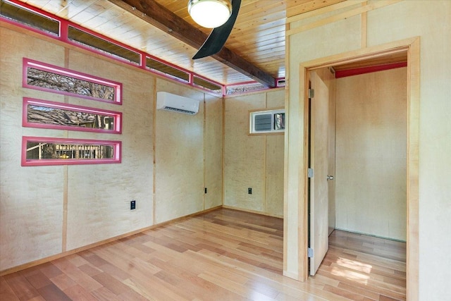 spare room with beamed ceiling, wood ceiling, wood finished floors, and a wall mounted AC