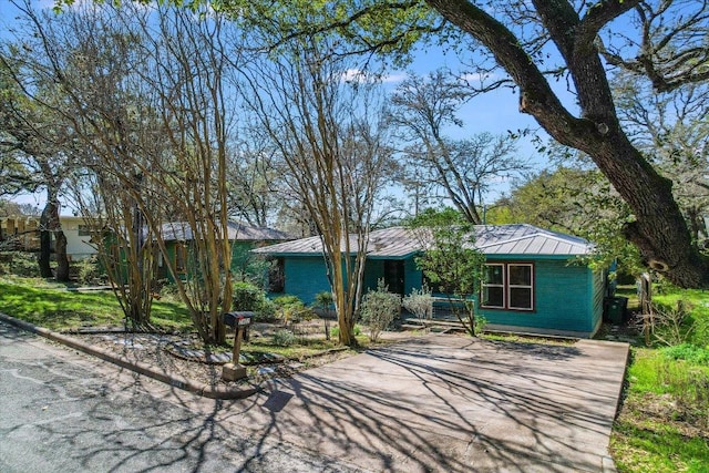 view of front of property with concrete driveway and metal roof