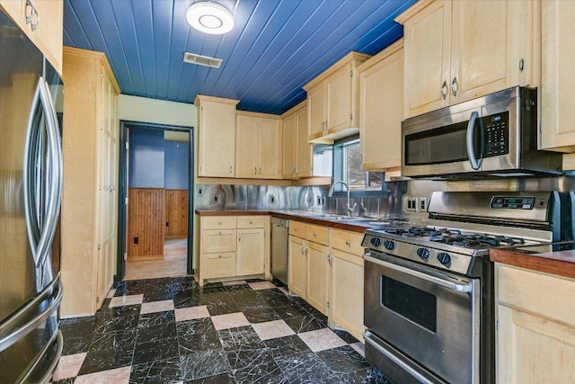 kitchen with light brown cabinetry, visible vents, wooden ceiling, and stainless steel appliances