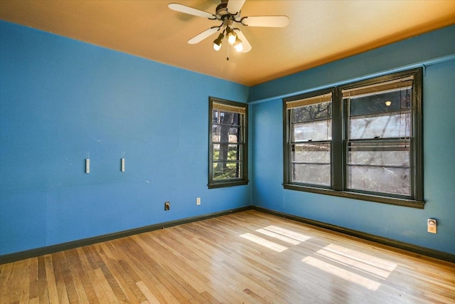 unfurnished room with ceiling fan, baseboards, and wood finished floors