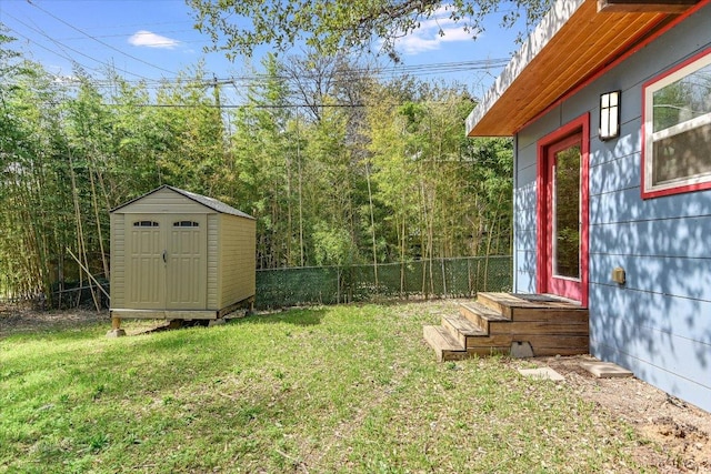 view of yard with a storage unit, an outdoor structure, and fence