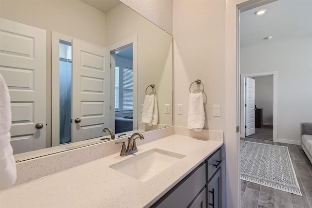 bathroom with vanity, baseboards, and wood finished floors