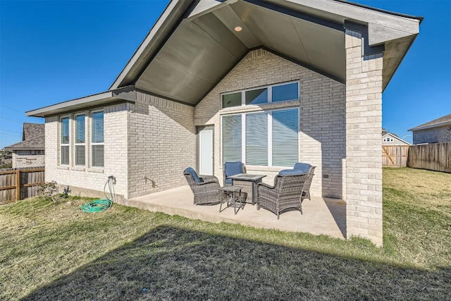 back of property featuring a yard, brick siding, a patio, and a fenced backyard