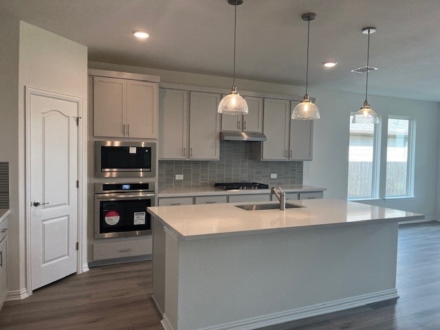 513 Teasley Dr, Taylor, TX 76574 - kitchen featuring appliances with stainless steel finishes, dark wood-style flooring, tasteful backsplash, light countertops, and recessed lighting