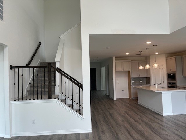 513 Teasley Dr, Taylor, TX 76574 - kitchen featuring built in microwave, oven, dark wood-style floors, recessed lighting, and an island with sink