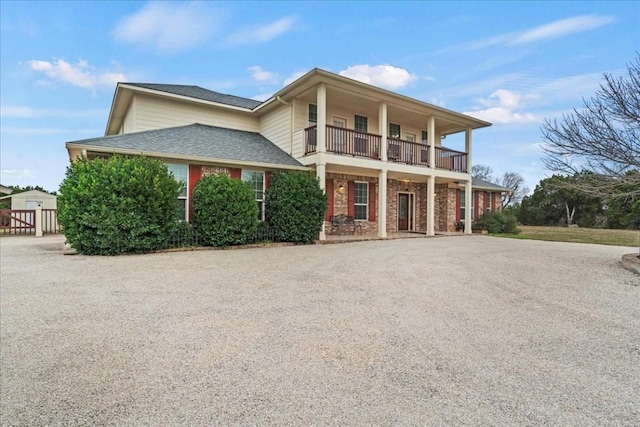 130 Cave Springs Rd, Wimberley, TX 78676 - view of front facade with a balcony, a porch, asphalt driveway, and brick siding