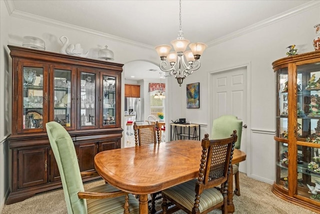 dining room with crown molding, light colored carpet, and an inviting chandelier