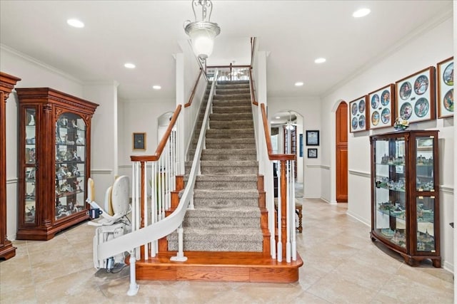 staircase featuring arched walkways, ornamental molding, and recessed lighting