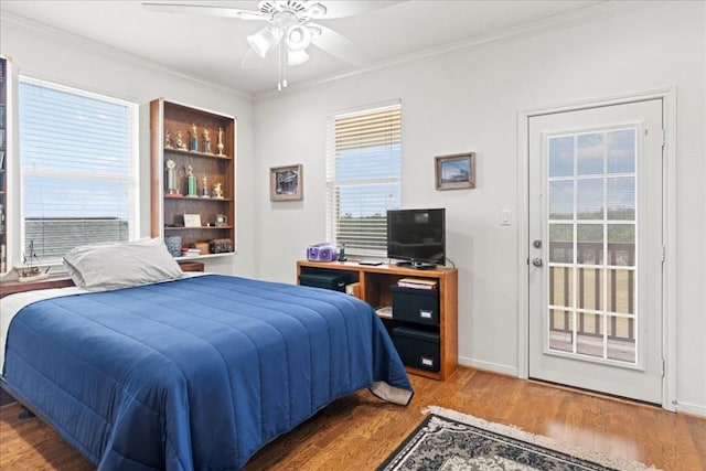 bedroom featuring baseboards, ceiling fan, ornamental molding, wood finished floors, and access to outside