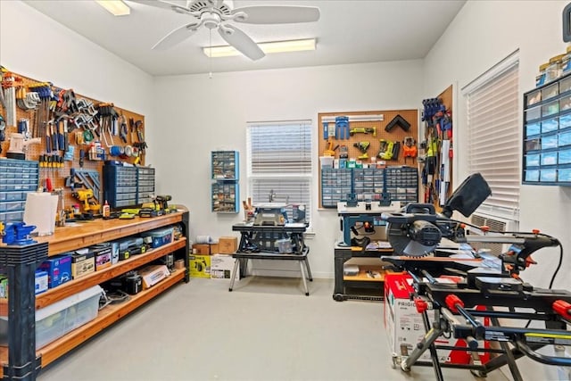 misc room with a ceiling fan, finished concrete flooring, and a workshop area