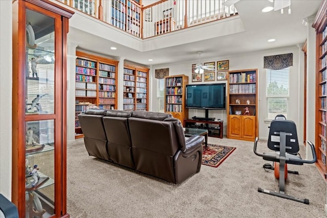 living room with built in shelves, carpet, bookshelves, and recessed lighting