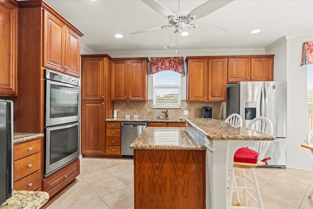 130 Cave Springs Rd, Wimberley, TX 78676 - kitchen with stainless steel appliances, crown molding, light tile patterned floors, a kitchen breakfast bar, and tasteful backsplash