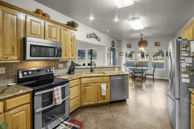 kitchen featuring a sink, finished concrete flooring, stainless steel appliances, a peninsula, and decorative backsplash