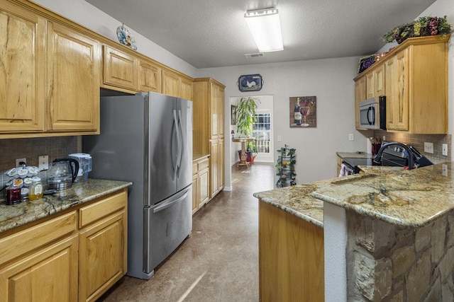 kitchen featuring light stone countertops, tasteful backsplash, appliances with stainless steel finishes, and light floors