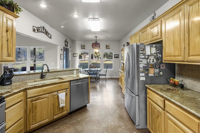 kitchen featuring baseboards, light stone counters, decorative backsplash, stainless steel appliances, and a sink