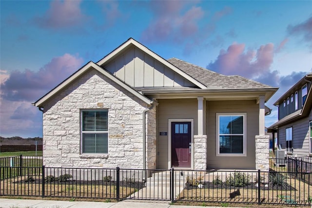 121 Pinnacle Ln, Kyle, TX 78640 - craftsman-style house featuring stone siding, board and batten siding, a fenced front yard, and a shingled roof