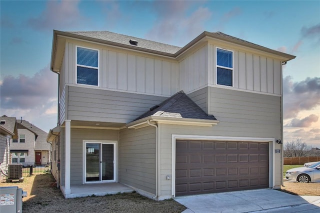 121 Pinnacle Ln, Kyle, TX 78640 - view of front of home featuring central AC unit, board and batten siding, a garage, and concrete driveway