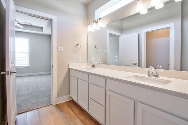 121 Pinnacle Ln, Kyle, TX 78640 - full bathroom featuring double vanity, baseboards, wood finished floors, and a ceiling fan