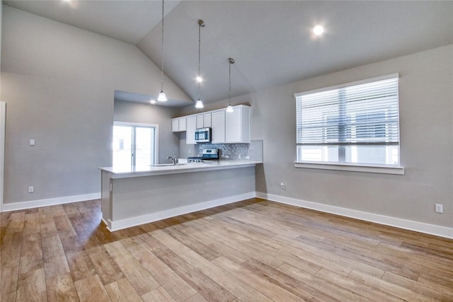 121 Pinnacle Ln, Kyle, TX 78640 - kitchen featuring range, white cabinets, stainless steel microwave, light wood-style flooring, and light countertops