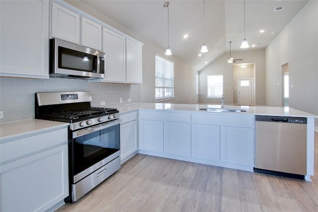 121 Pinnacle Ln, Kyle, TX 78640 - kitchen with appliances with stainless steel finishes, a sink, backsplash, light countertops, and vaulted ceiling