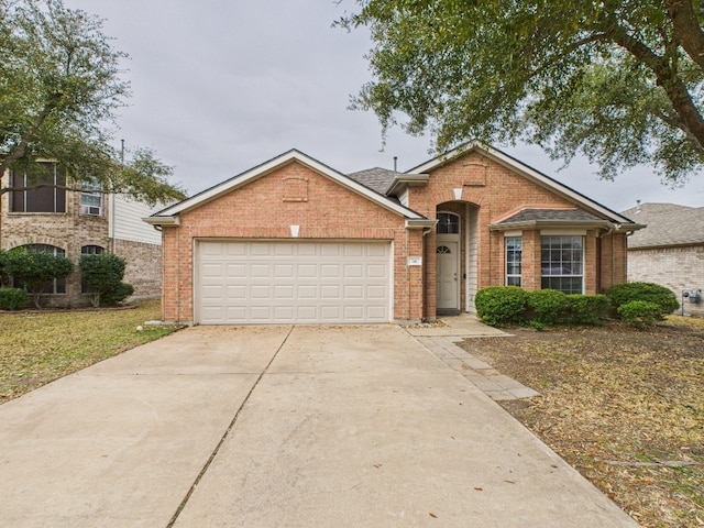 view of front of home featuring a garage, concrete driveway, and brick siding