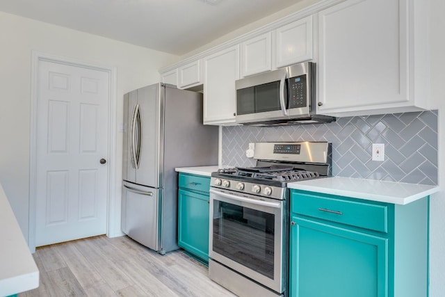 kitchen with light wood finished floors, backsplash, stainless steel appliances, and light countertops