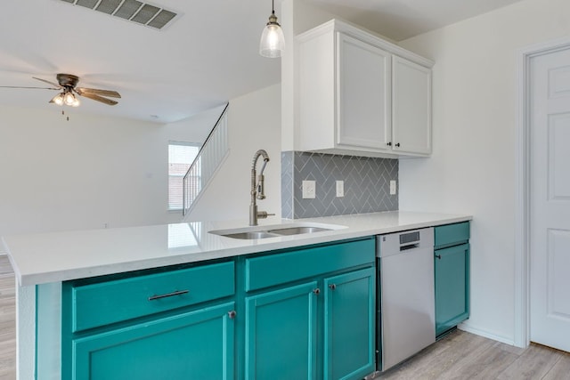 kitchen with tasteful backsplash, light countertops, visible vents, stainless steel dishwasher, and a sink