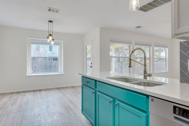 kitchen featuring light countertops, visible vents, a sink, light wood-type flooring, and dishwashing machine