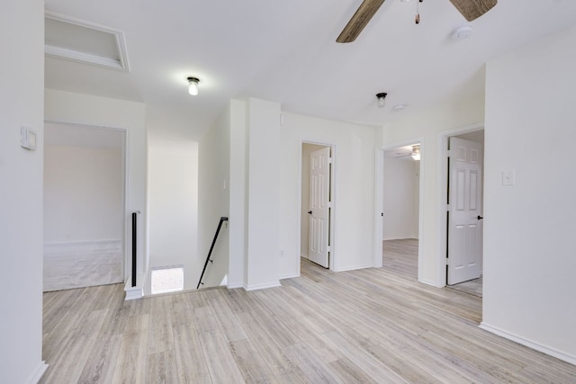 empty room with ceiling fan, baseboards, visible vents, and light wood-style floors