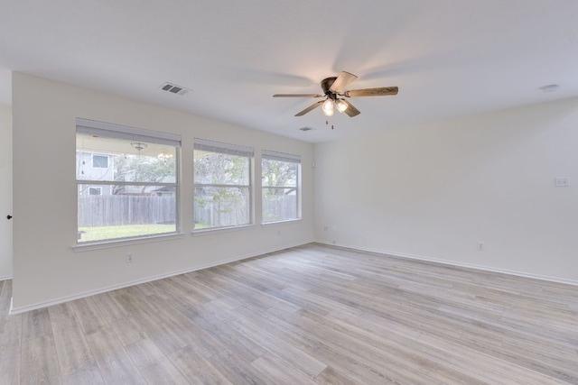 unfurnished room featuring light wood-type flooring, baseboards, visible vents, and a ceiling fan