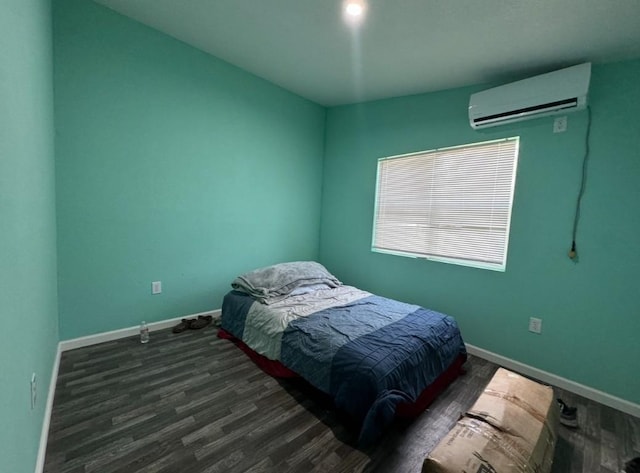 bedroom featuring baseboards, wood finished floors, and a wall mounted AC