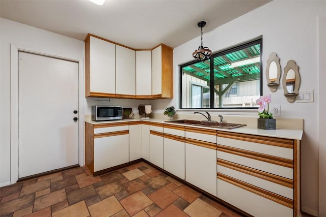 9504 Quail Village Ln, Austin, TX 78758 - kitchen with stainless steel microwave, white cabinets, and light countertops