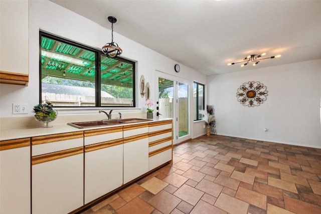 9504 Quail Village Ln, Austin, TX 78758 - kitchen with white cabinetry, light countertops, and decorative light fixtures
