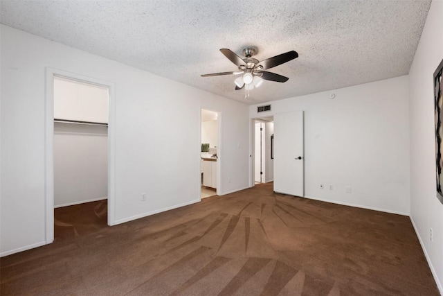 9504 Quail Village Ln, Austin, TX 78758 - unfurnished bedroom with carpet, a walk in closet, a textured ceiling, a closet, and ceiling fan