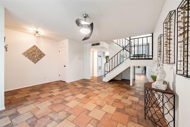 interior space with stone finish flooring, visible vents, stairway, and baseboards