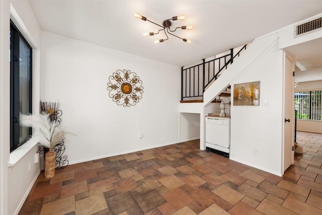 9504 Quail Village Ln, Austin, TX 78758 - unfurnished living room featuring a chandelier and stone finish floors