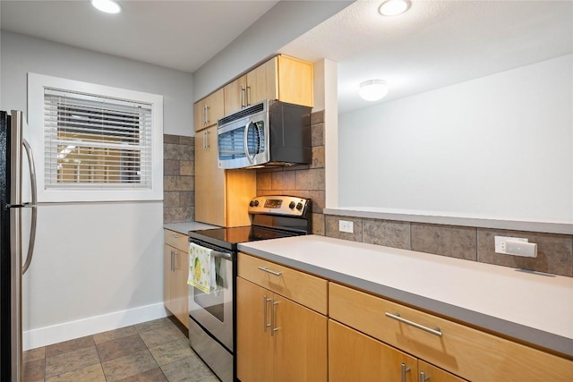 kitchen featuring backsplash, baseboards, light countertops, recessed lighting, and appliances with stainless steel finishes