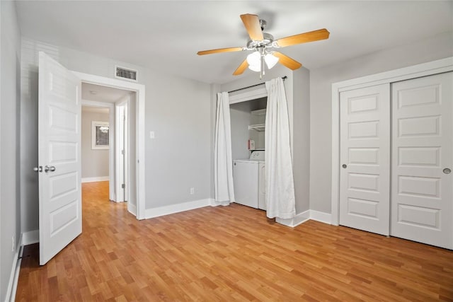 unfurnished bedroom with separate washer and dryer, visible vents, light wood finished floors, and baseboards