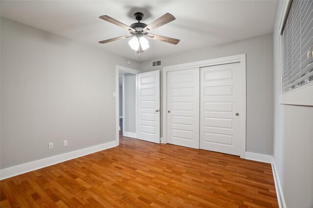 unfurnished bedroom featuring a closet, visible vents, baseboards, and light wood finished floors