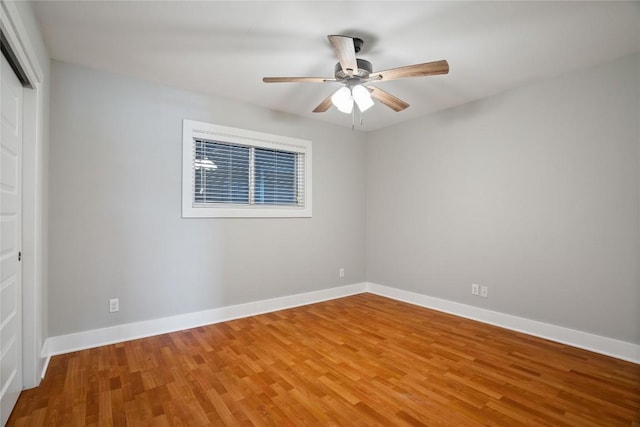 spare room with ceiling fan, baseboards, and wood finished floors