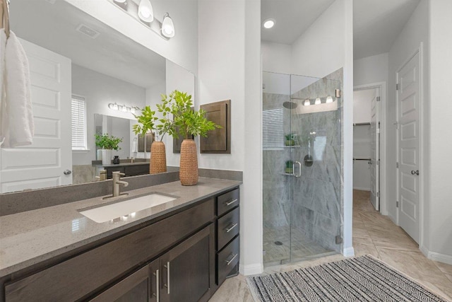 bathroom featuring visible vents, a stall shower, vanity, and baseboards