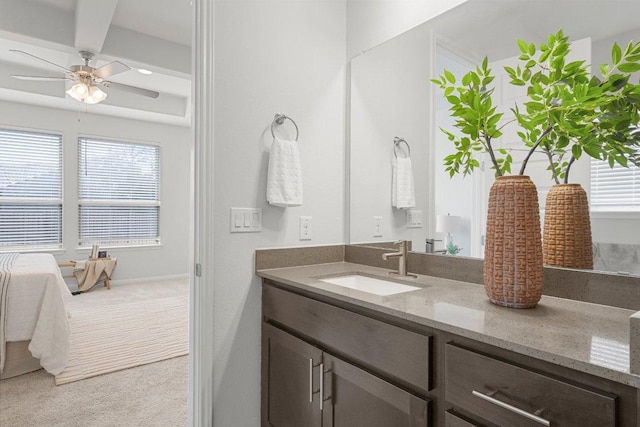 bathroom featuring a ceiling fan, beamed ceiling, vanity, and a healthy amount of sunlight