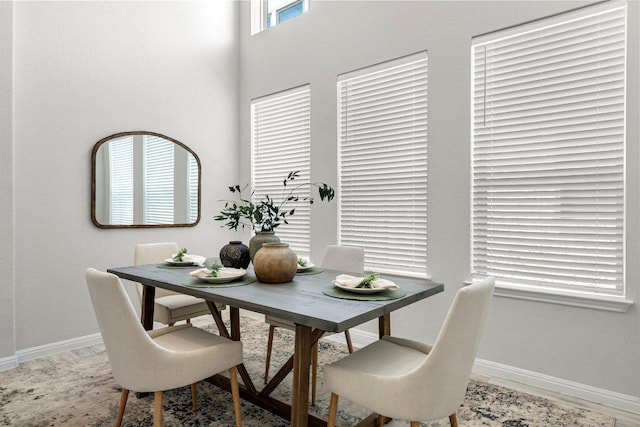 dining room with a towering ceiling and baseboards