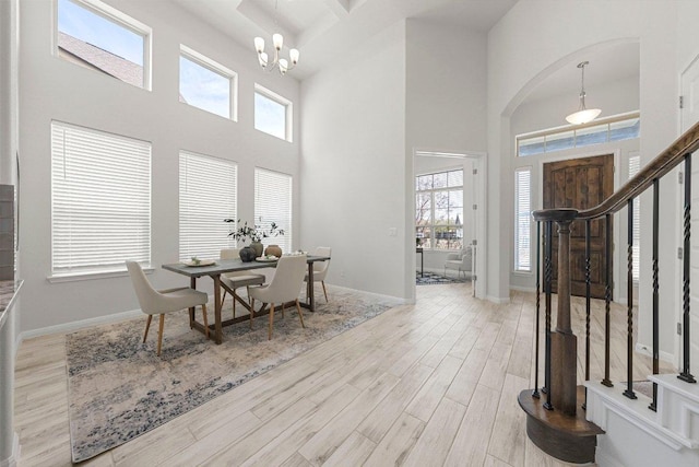 entrance foyer with a healthy amount of sunlight, a notable chandelier, stairway, and wood finished floors