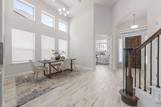 entryway with baseboards, a high ceiling, wood finished floors, and a healthy amount of sunlight