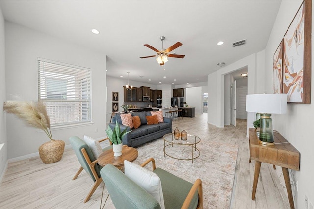 living room featuring baseboards, light wood-type flooring, recessed lighting, a ceiling fan, and visible vents