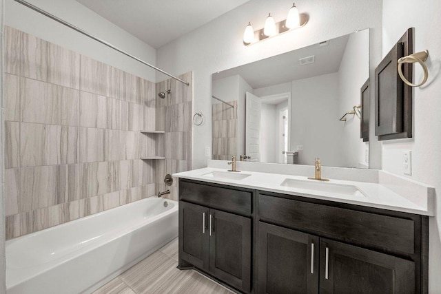 bathroom featuring  shower combination, double vanity, a sink, and visible vents