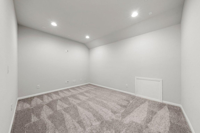 carpeted empty room with recessed lighting, lofted ceiling, and baseboards