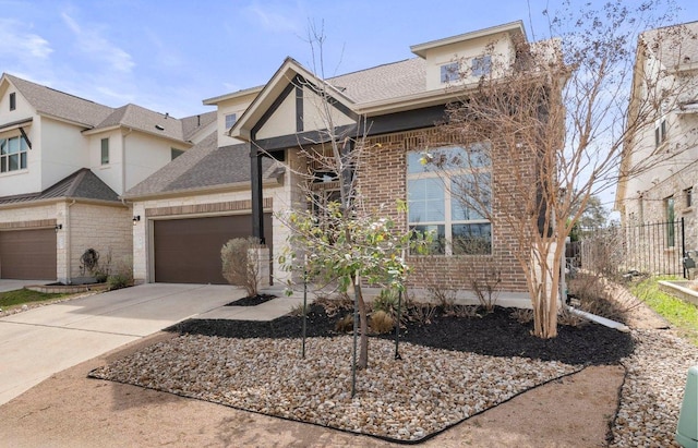 view of front of home featuring concrete driveway, brick siding, roof with shingles, and fence