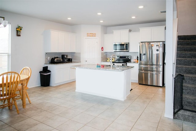 kitchen featuring light stone countertops, appliances with stainless steel finishes, recessed lighting, white cabinetry, and decorative backsplash